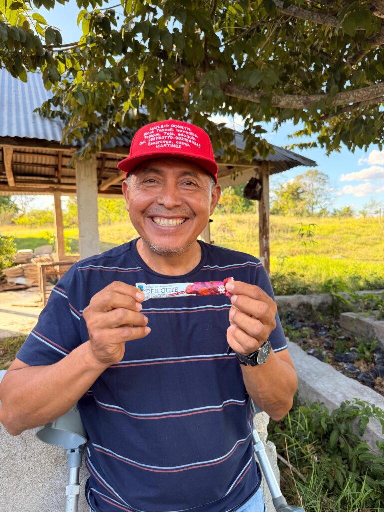 Landwirt Ramses hält den Guten Riegel in zwei Händen und lächelt in die Kamera.